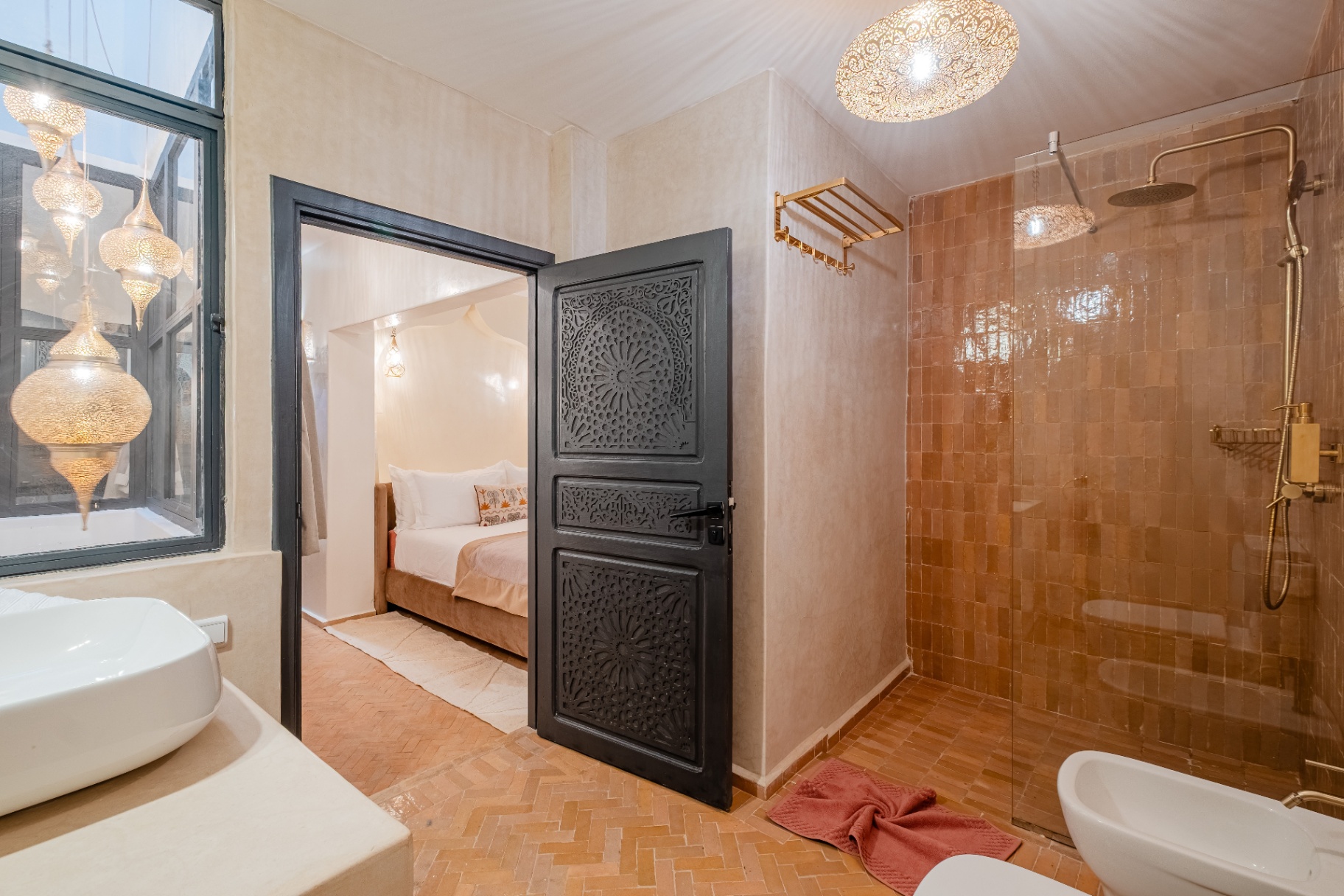 Salle de bain en zellige terracotta et porte sculptée